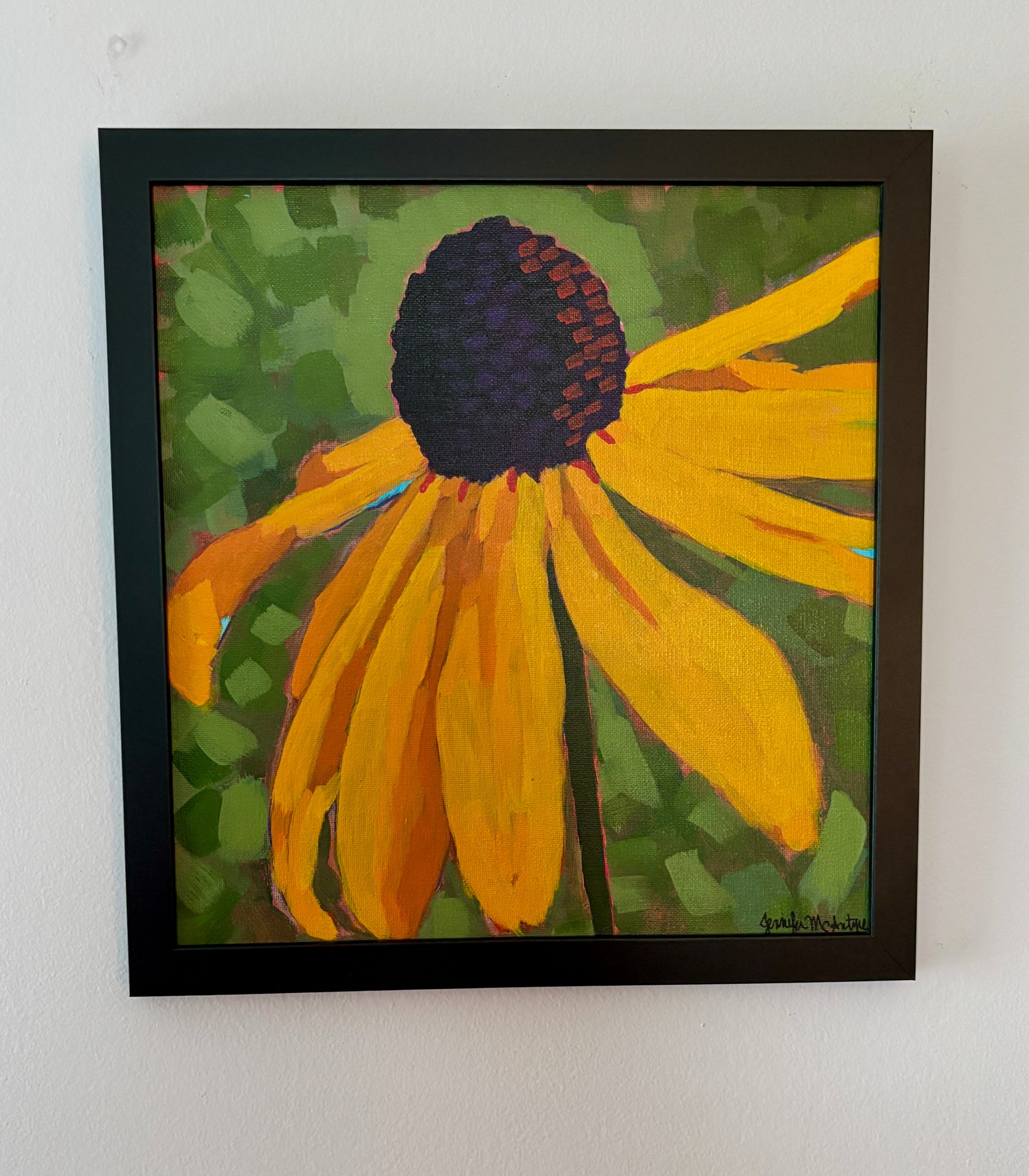 Framed painting of a yellow flower with a black frame on a white wall.