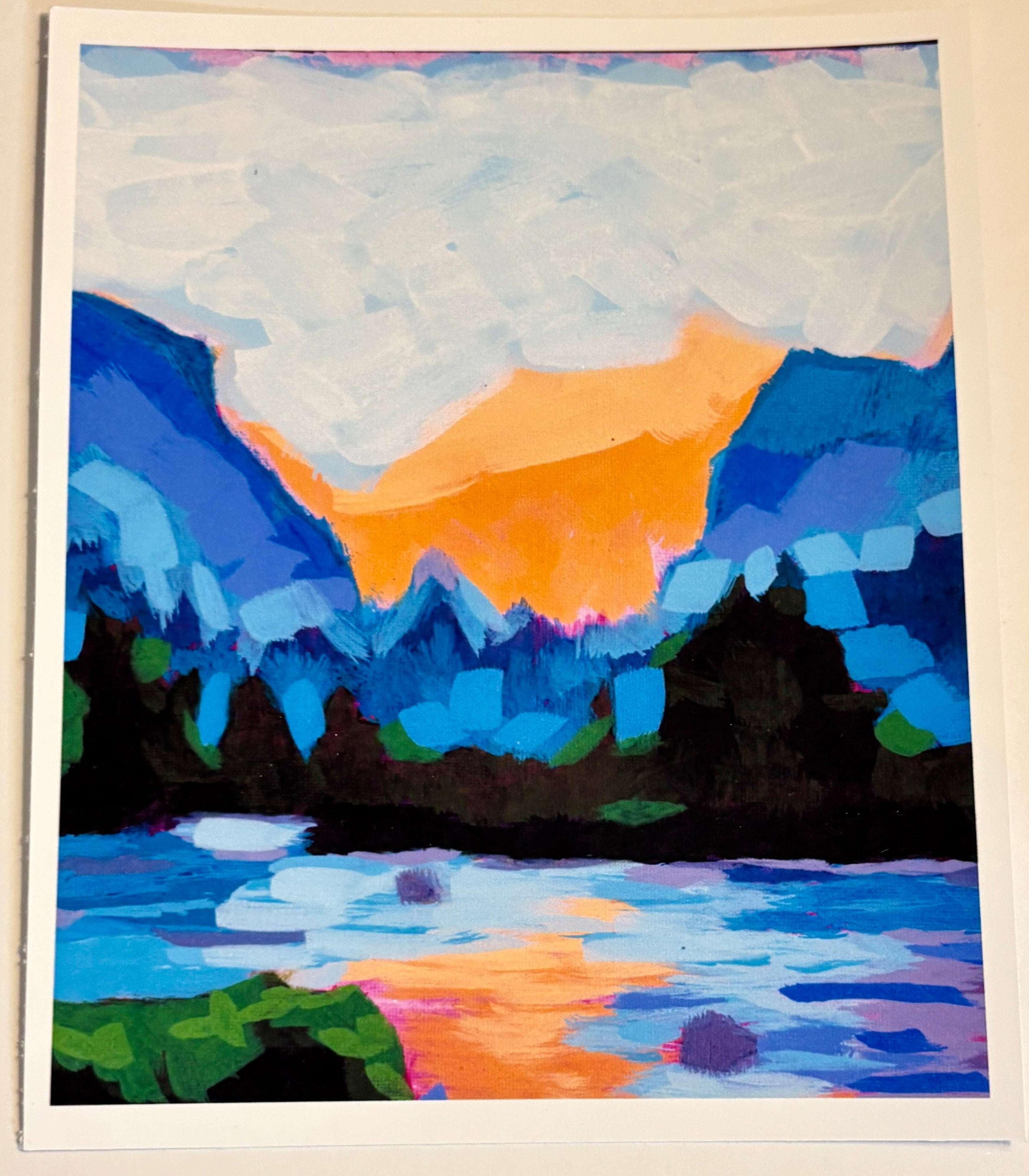 Colorful abstract painting of a mountain landscape on a beige wall.