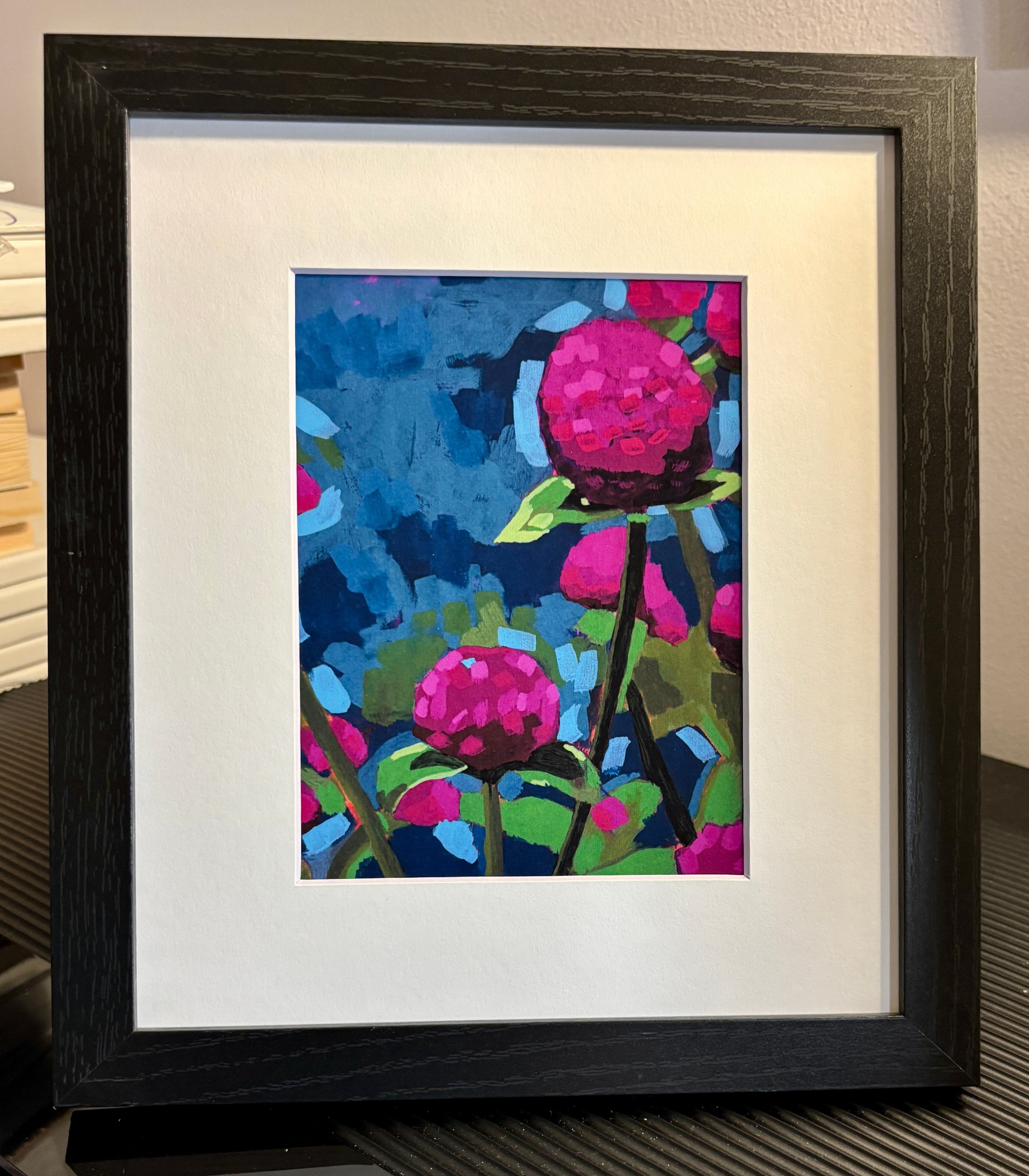 Framed abstract artwork with pink flowers on a blue background